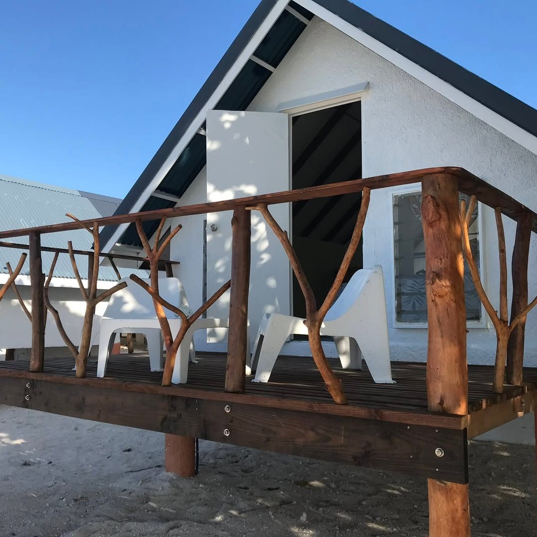 Terrasse en bois flotté d'un bungalow avec deux fauteuils blancs